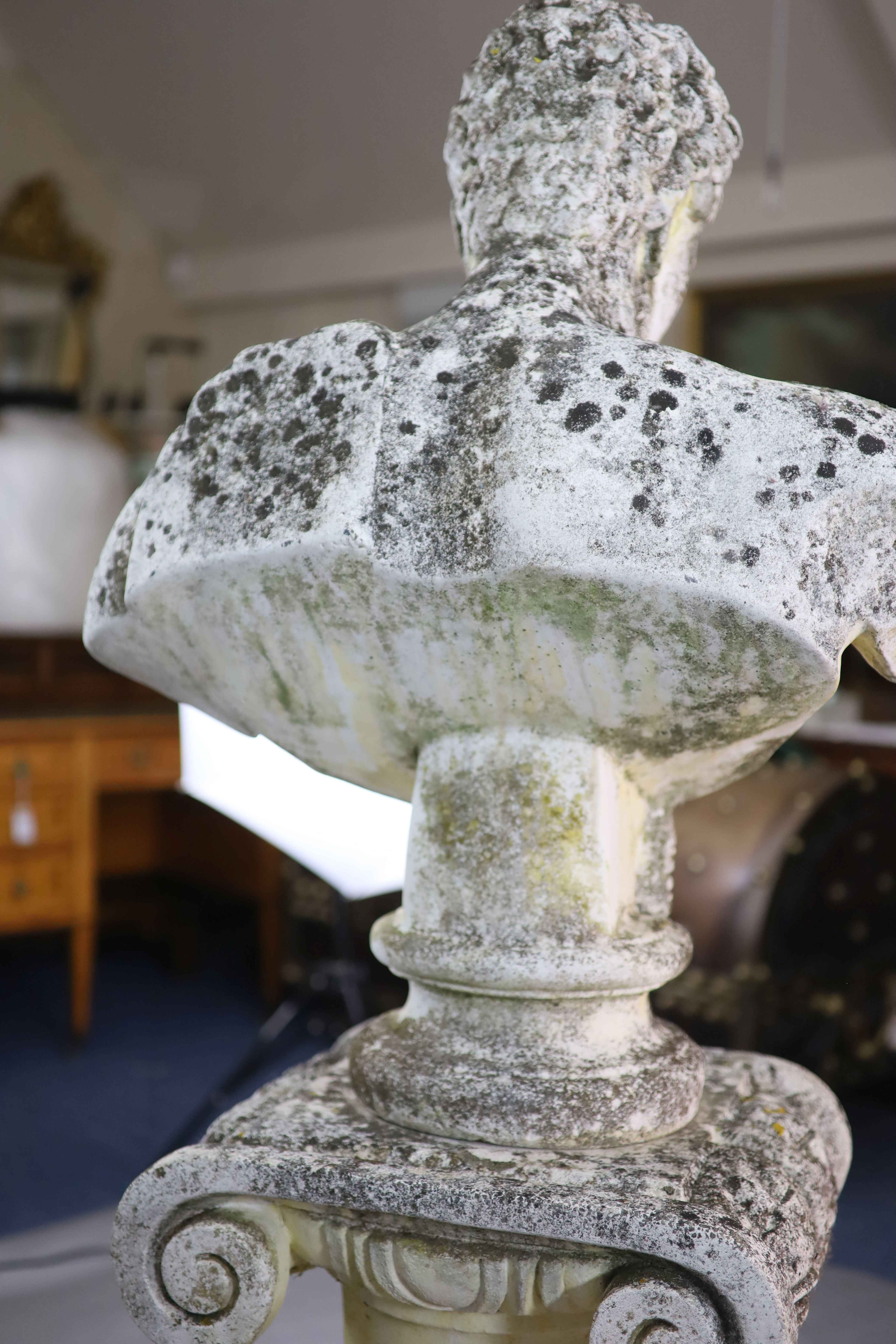 A reconstituted stone bust of a classical youth standing upon an ionic column pedestal, bust 2ft 7in. pedestal 2ft 5in.